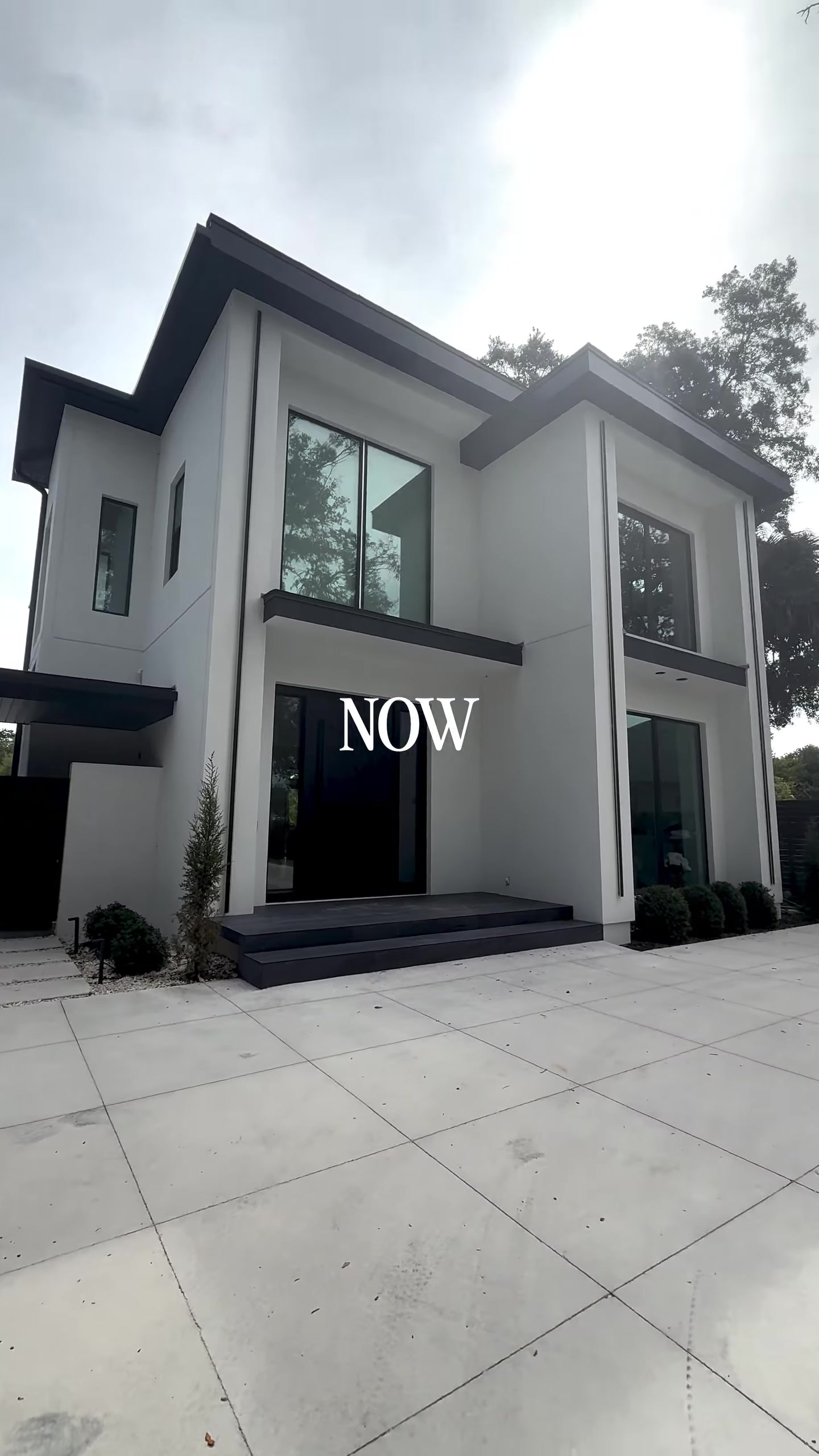 The same project's completed modern white exterior with black window frames